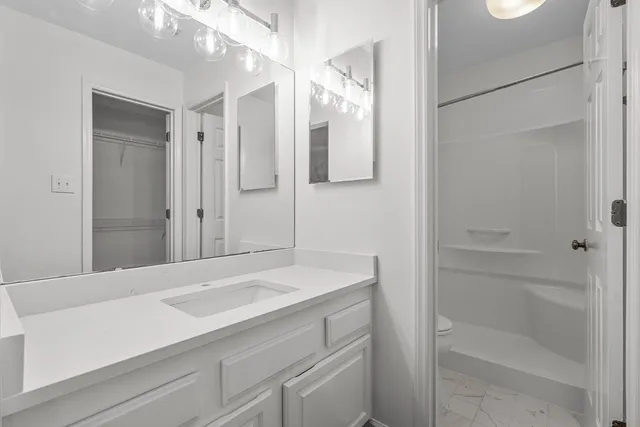 a bathroom with a sink a toilet and shower