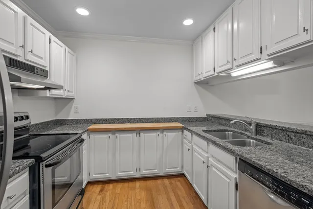 a kitchen with stainless steel appliances granite countertop a refrigerator stove and cabinets