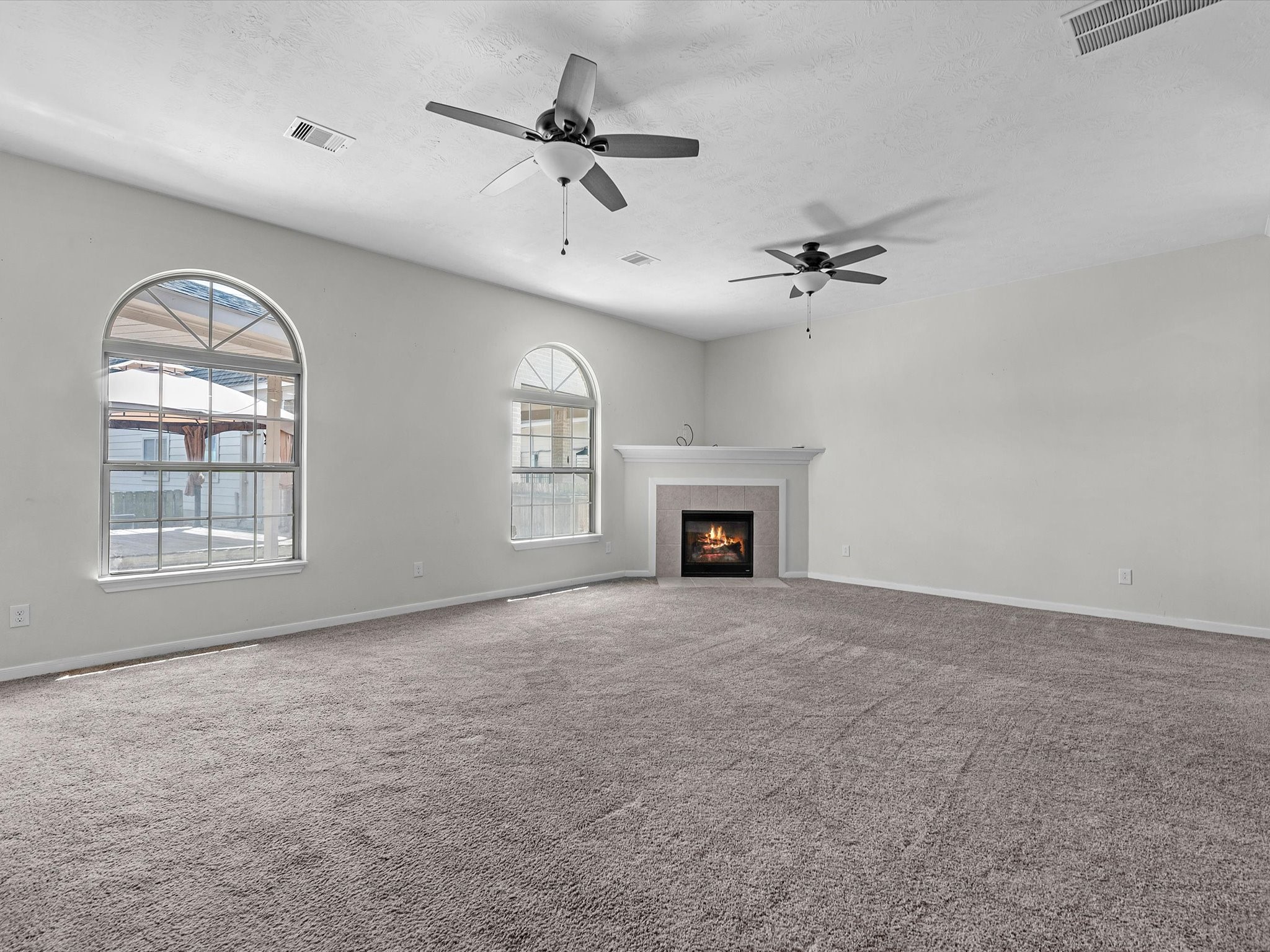 38 Palmero Way Manvel, TX 77578 - Photo 11 of 43 an empty room with windows fireplace and fan