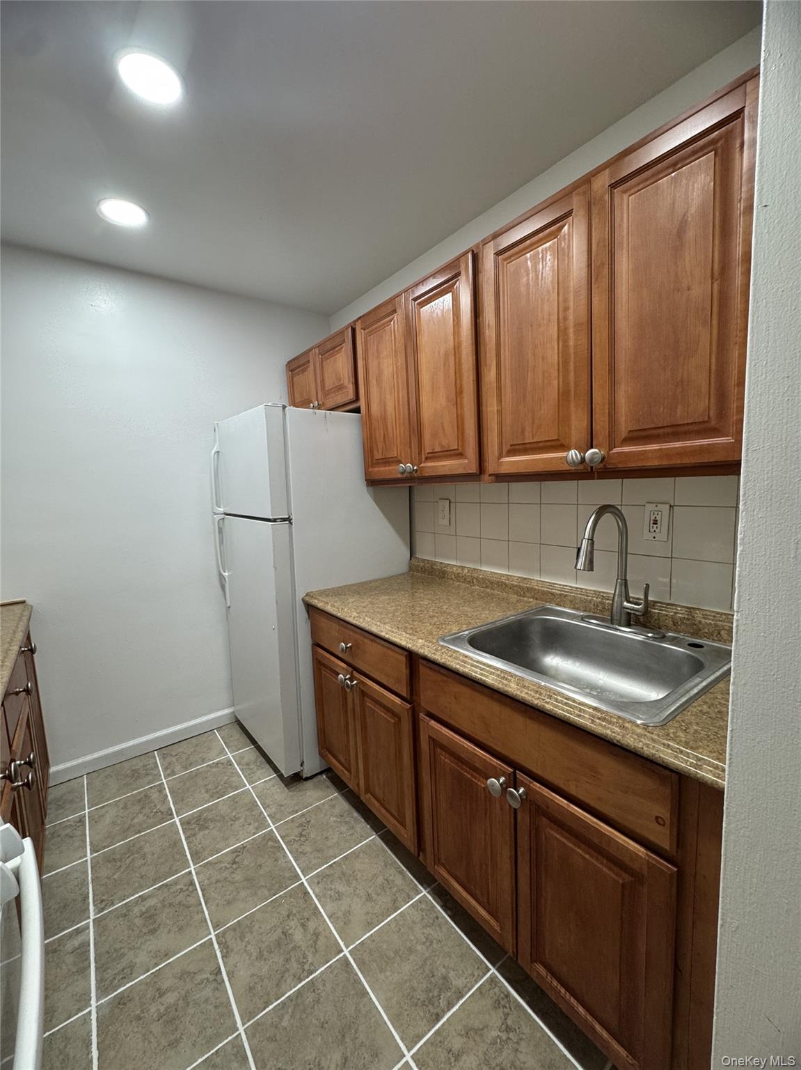 30 South Cole Avenue, Unit 1L Spring Valley, NY 10977 - Photo 18 of 29 a kitchen with a sink a refrigerator and cabinets