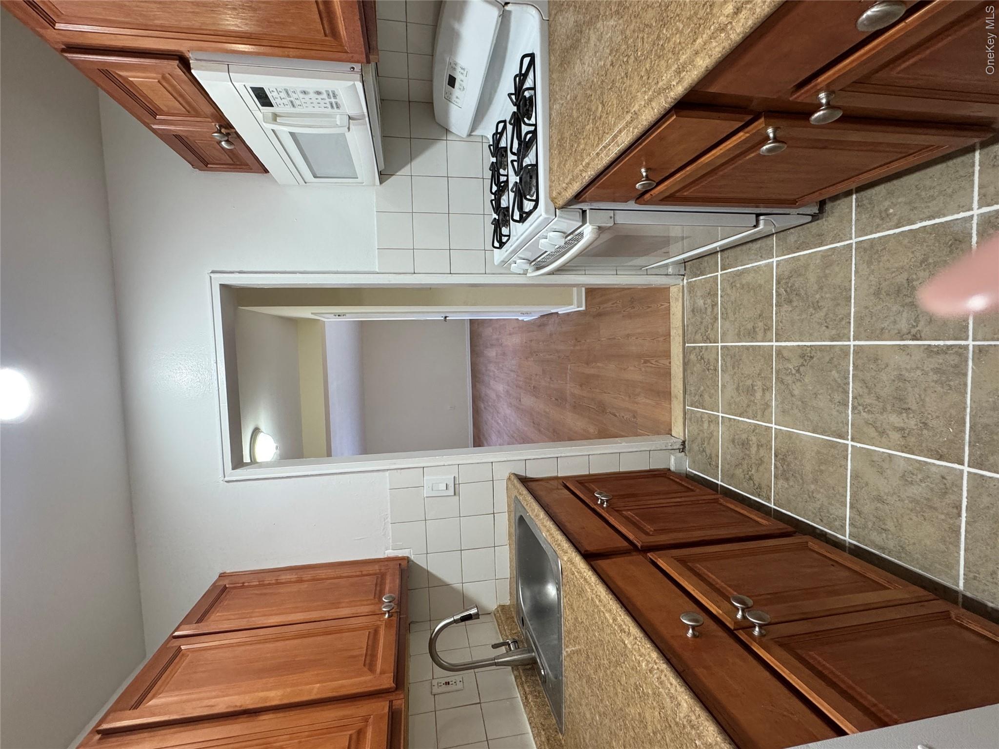 30 South Cole Avenue, Unit 1L Spring Valley, NY 10977 - Photo 20 of 29 a kitchen with a sink a stove and cabinets