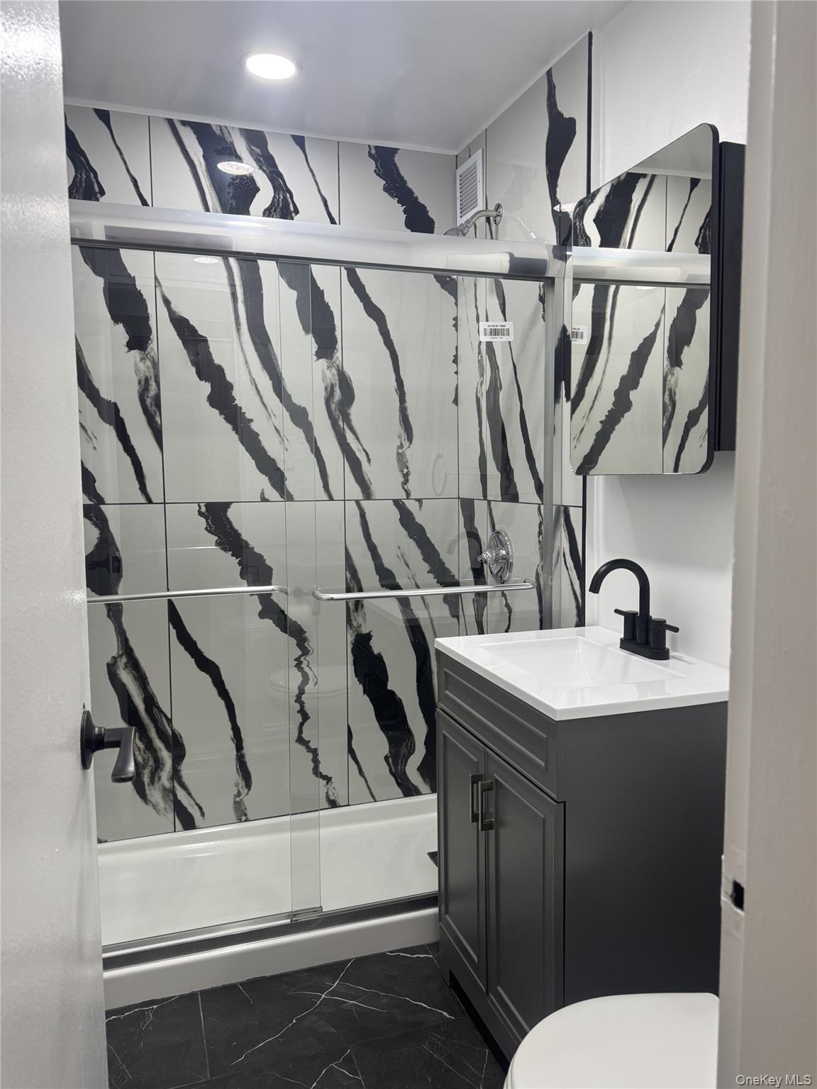 30 South Cole Avenue, Unit 1L Spring Valley, NY 10977 - Photo 9 of 29 a bathroom with a toilet sink and mirror