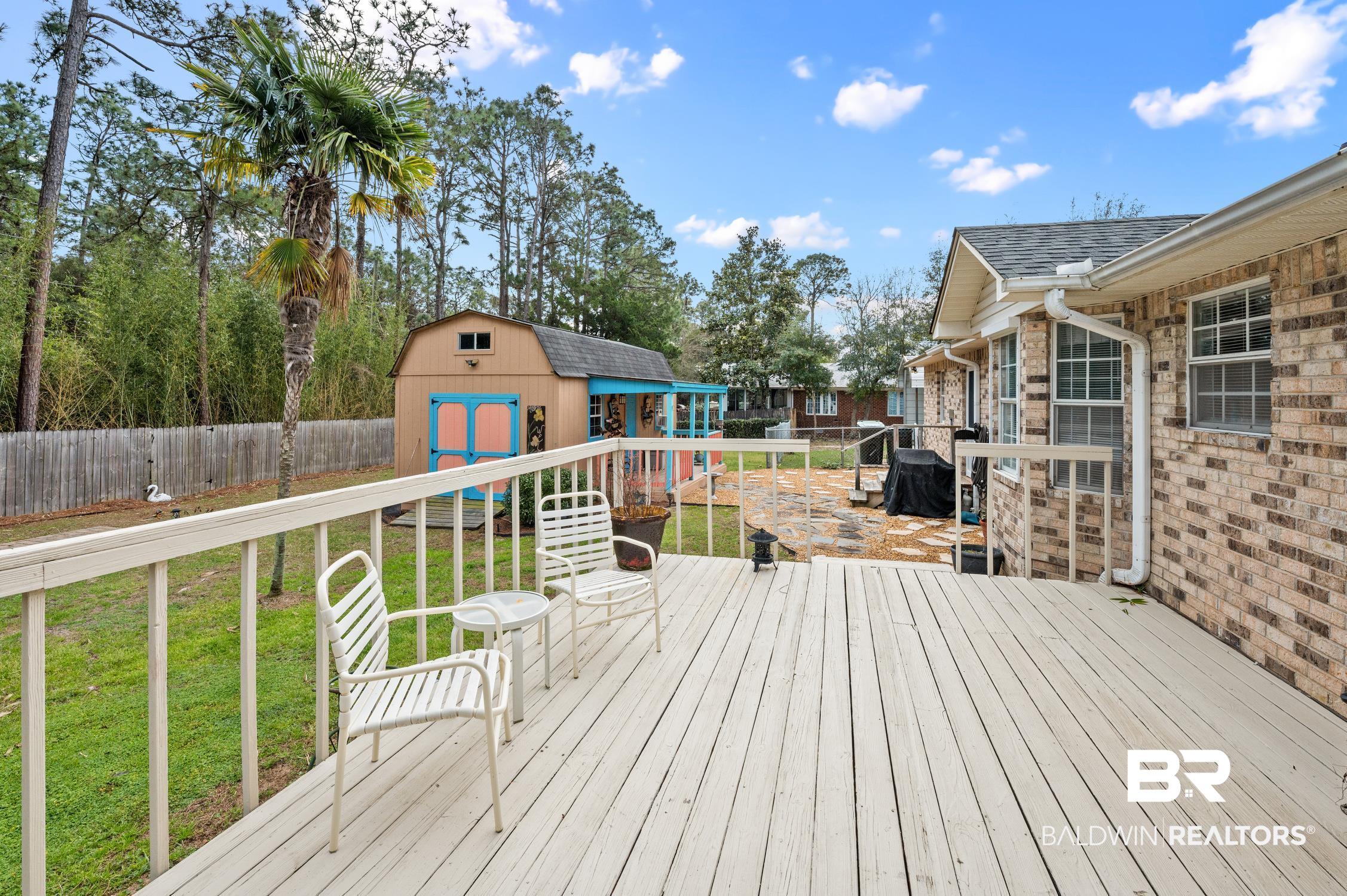 2553 Santa Rosa Drive Lillian, AL 36549 - Photo 38 of 51 Wooden terrace featuring a yard, a storage unit, an outdoor structure, and a fenced backyard