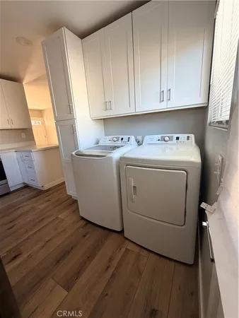 a utility room with wooden floor washer and dryer