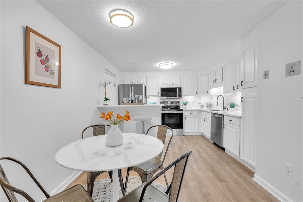 25 Pine Street, Unit B Canton, MA 02021 - Photo 8 of 23 a kitchen with stainless steel appliances a sink a stove a table and chairs