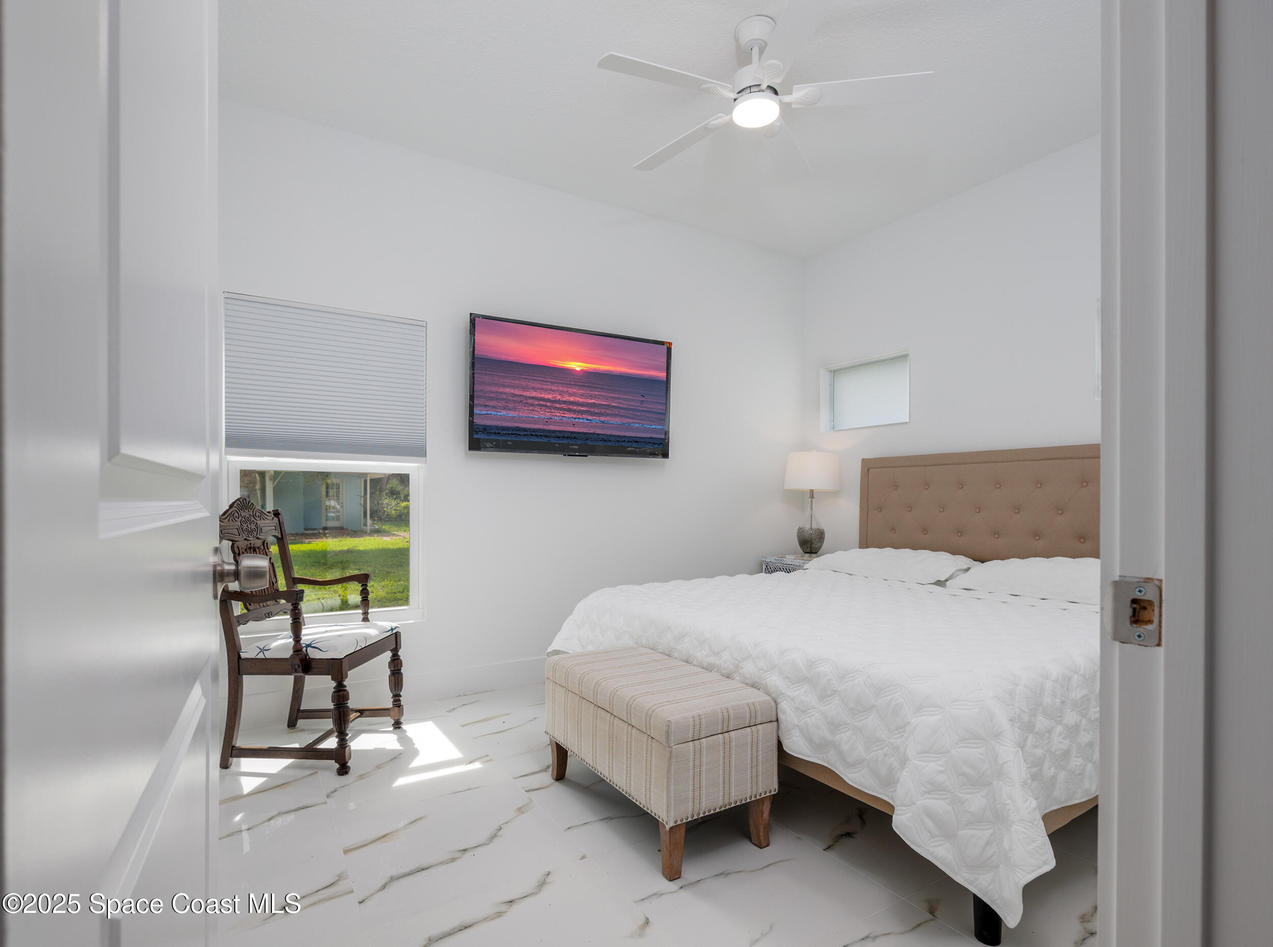 702 Shady Lane Melbourne, FL 32935 - Photo 11 of 14 a bedroom with a bed and a chair