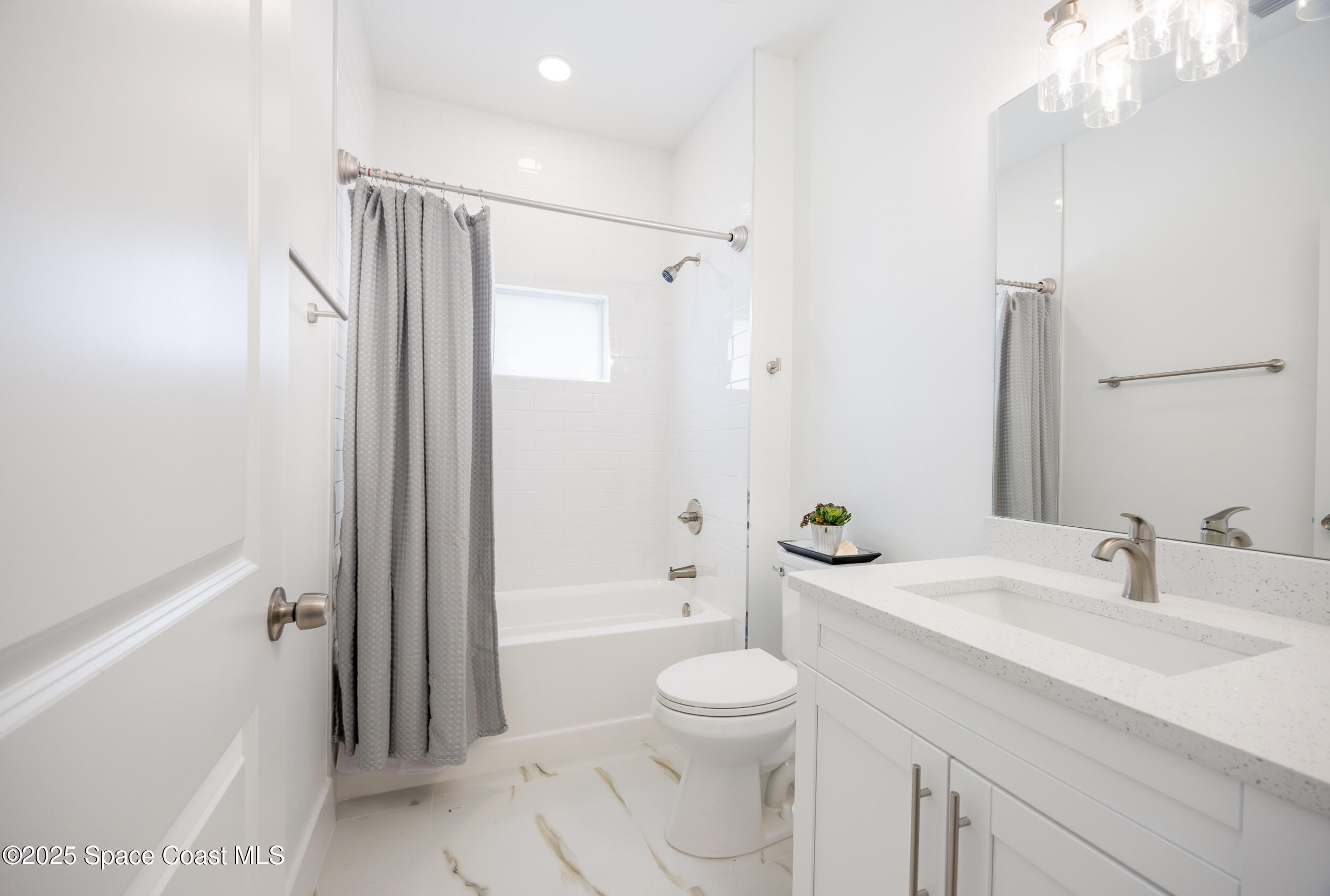 702 Shady Lane Melbourne, FL 32935 - Photo 13 of 14 a bathroom with a sink a toilet and shower