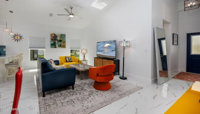 a living room with furniture kitchen view and a large window