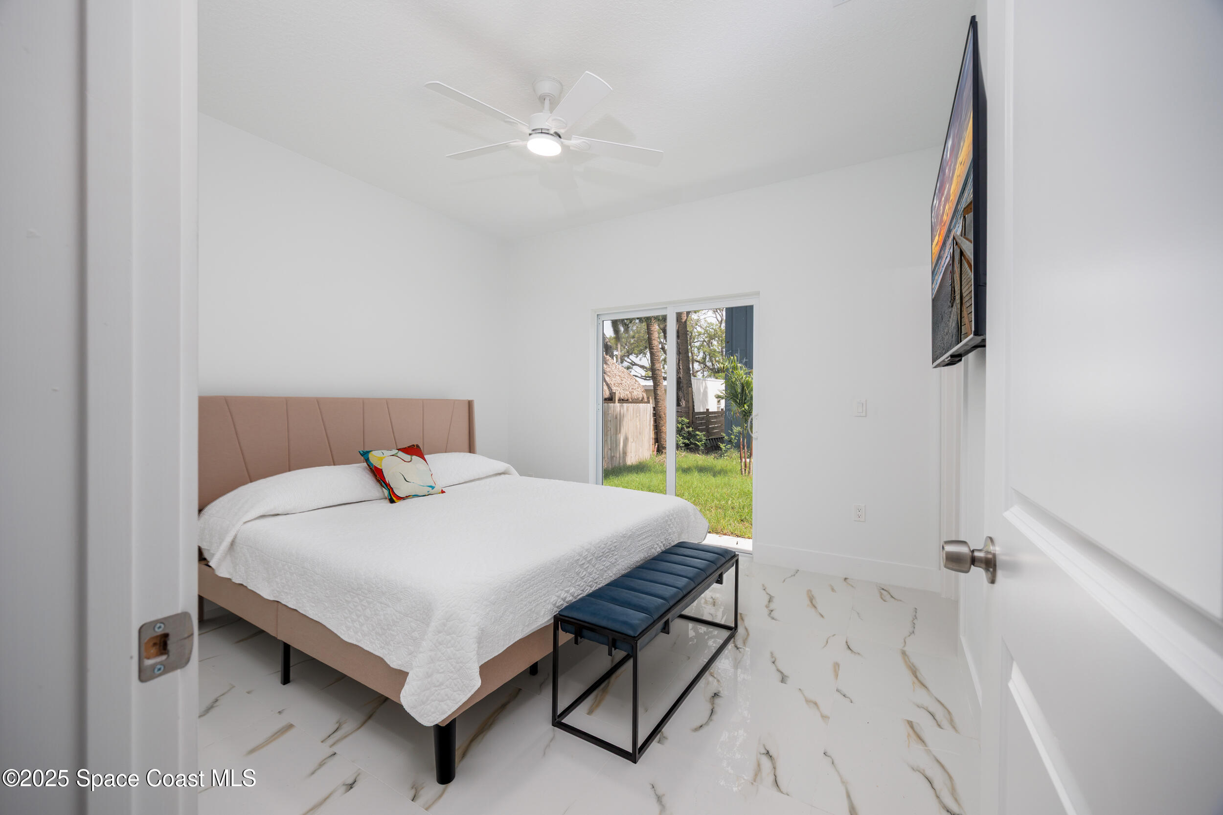 702 Shady Lane Melbourne, FL 32935 - Photo 8 of 14 a bed sitting in a bedroom next to a window
