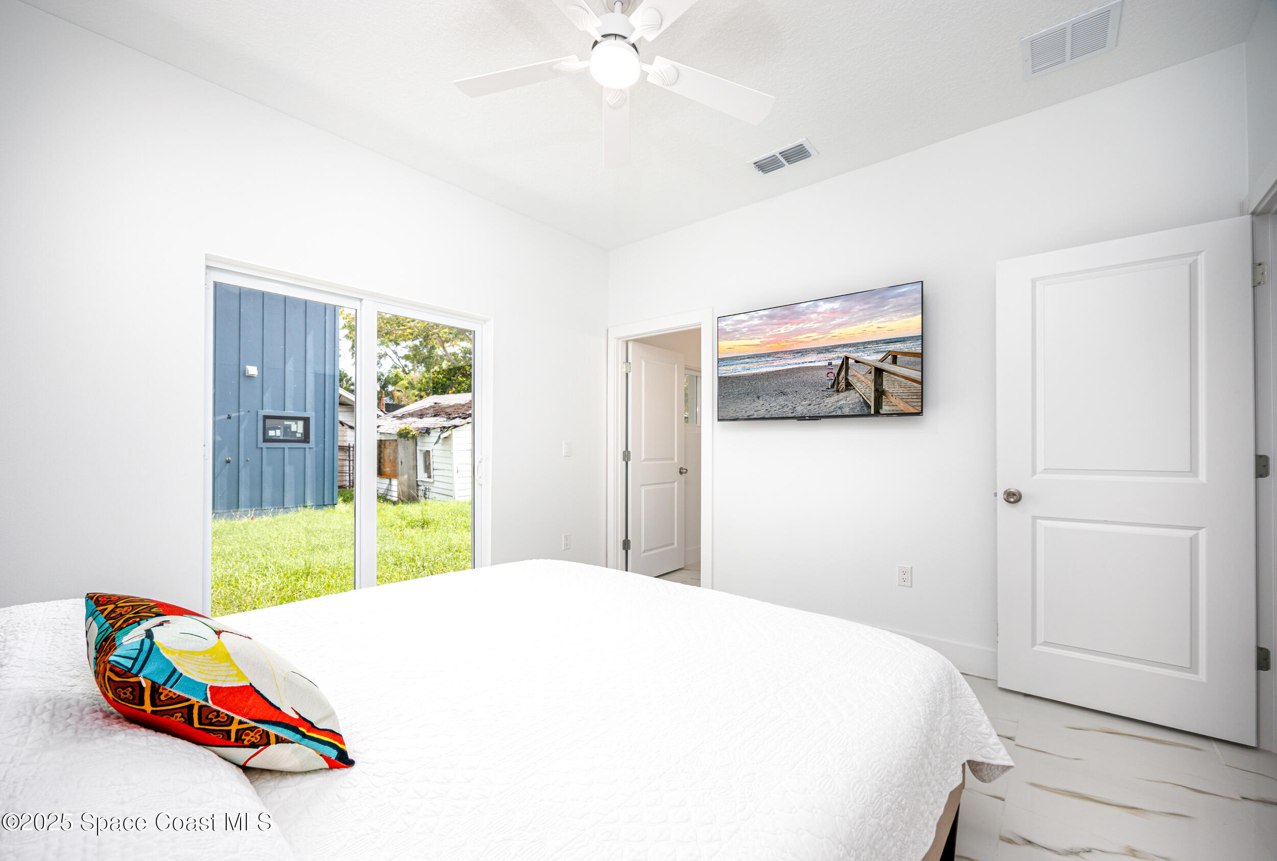 702 Shady Lane Melbourne, FL 32935 - Photo 9 of 14 a bedroom with a bed and a large mirror