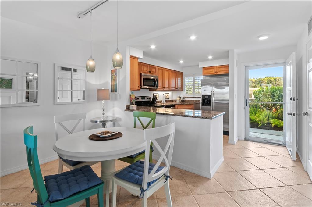 29 High Point Circle East, Unit 106 Naples, FL 34103 - Photo 11 of 42 a kitchen with a table and chairs
