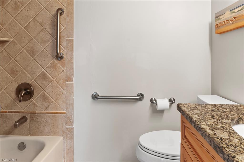 29 High Point Circle East, Unit 106 Naples, FL 34103 - Photo 16 of 42 a bathroom with a granite countertop sink toilet and shower