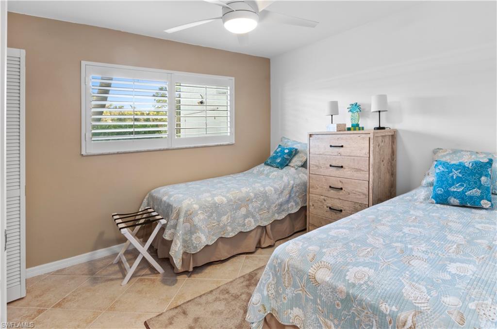 29 High Point Circle East, Unit 106 Naples, FL 34103 - Photo 17 of 42 a bedroom with two beds and a window