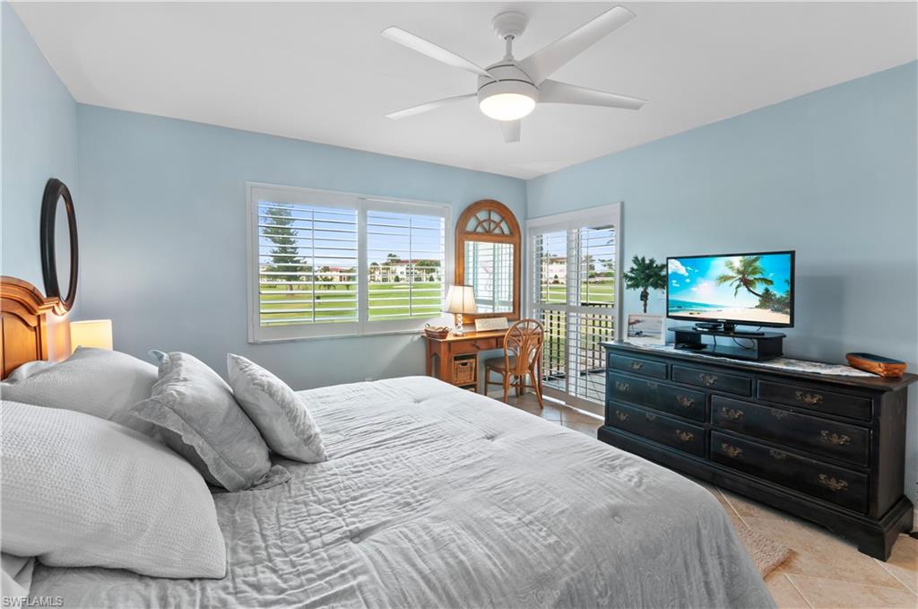 29 High Point Circle East, Unit 106 Naples, FL 34103 - Photo 21 of 42 a bedroom with a bed and a flat screen tv