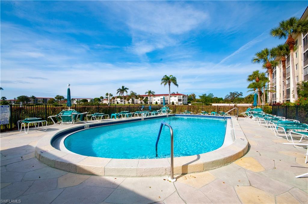 29 High Point Circle East, Unit 106 Naples, FL 34103 - Photo 25 of 42 a view of a swimming pool with a patio