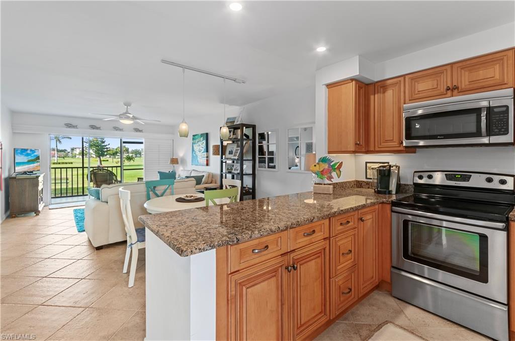 29 High Point Circle East, Unit 106 Naples, FL 34103 - Photo 5 of 42 a kitchen with stainless steel appliances granite countertop a stove a sink and a microwave