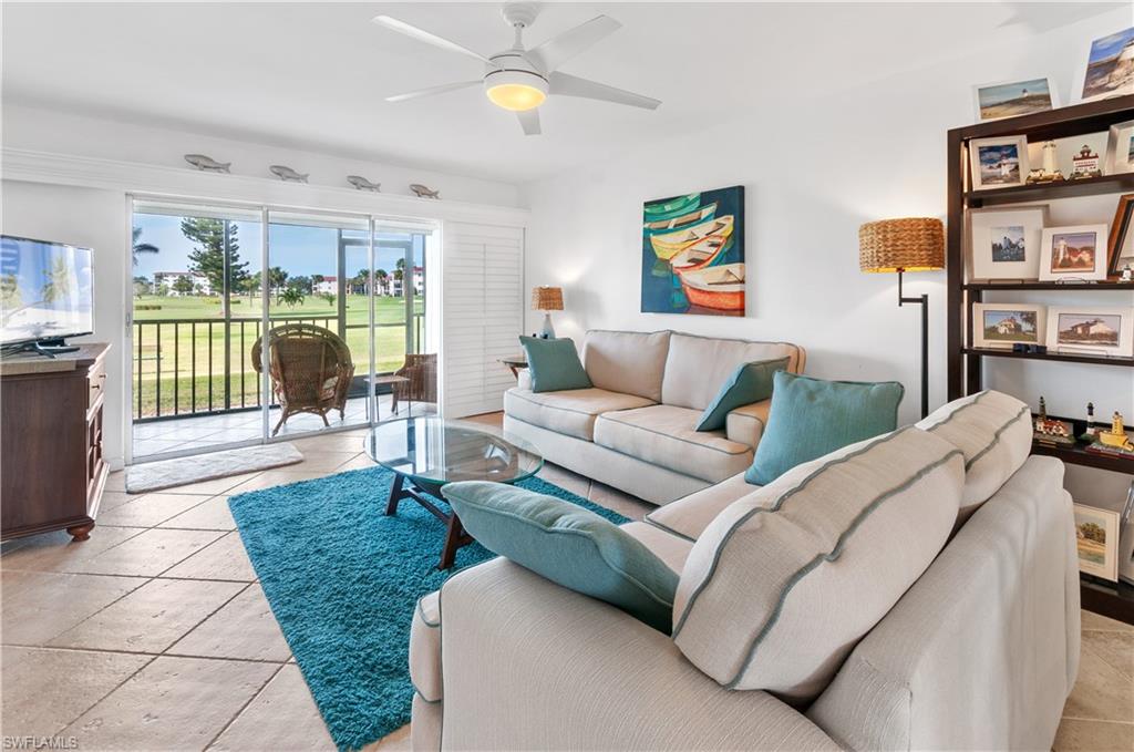 29 High Point Circle East, Unit 106 Naples, FL 34103 - Photo 9 of 42 a living room with furniture and a floor to ceiling window or chair