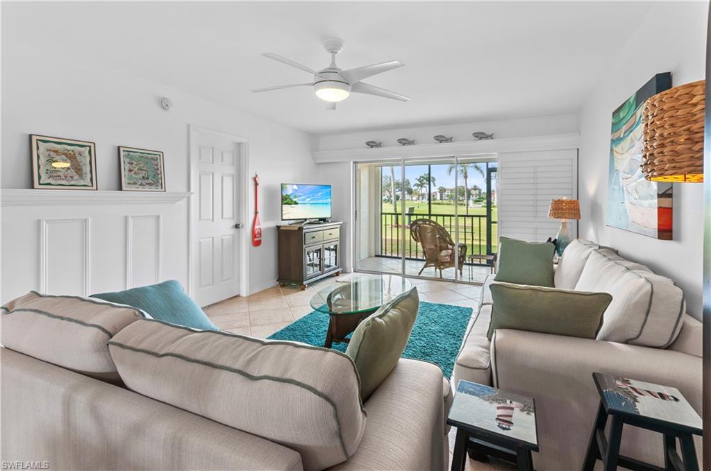29 High Point Circle East, Unit 106 Naples, FL 34103 - Photo 10 of 42 a living room with furniture and a large window