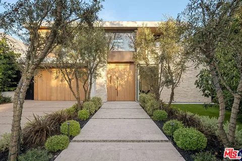 a front view of a house with a yard and tree
