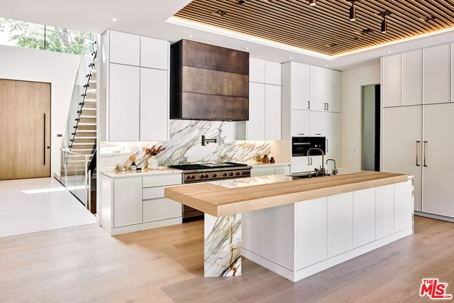 a kitchen with stainless steel appliances kitchen island granite countertop a sink and a refrigerator