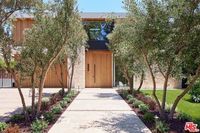a front view of a house with a yard and fountain