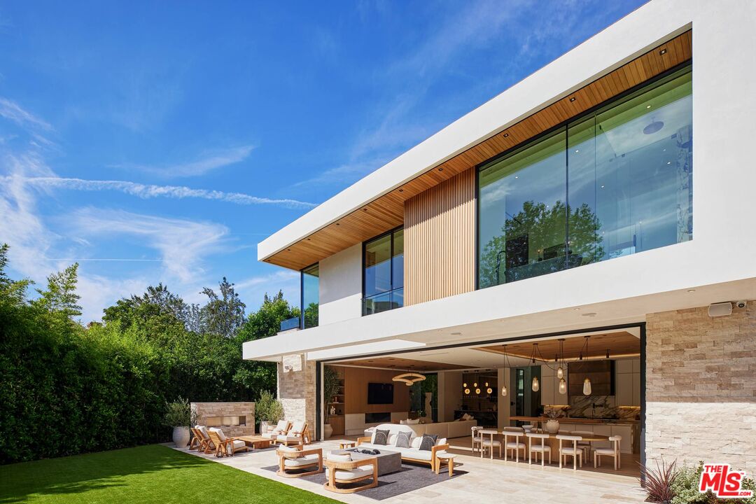 740 Warner Avenue Los Angeles, CA 90024 - Photo 36 of 53 a view of a patio with a table and chairs under an umbrella with a small yard