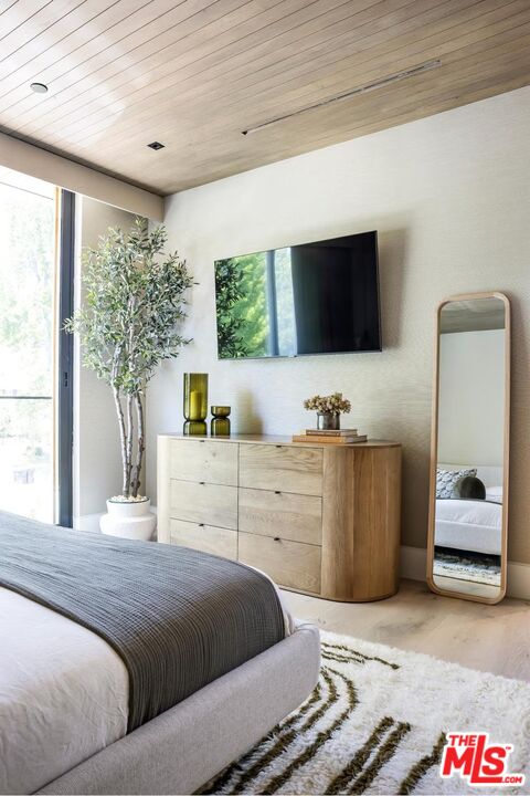 740 Warner Avenue Los Angeles, CA 90024 - Photo 49 of 53 a bedroom with a large bed and a flat tv screen on dresser