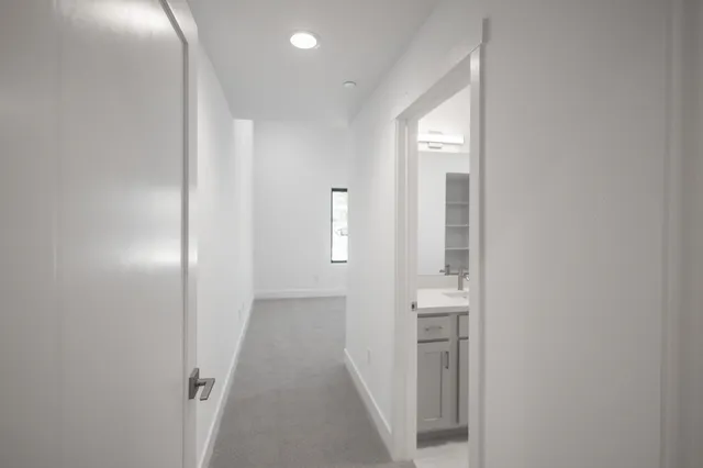 a view of a hallway with wooden floor and entryway