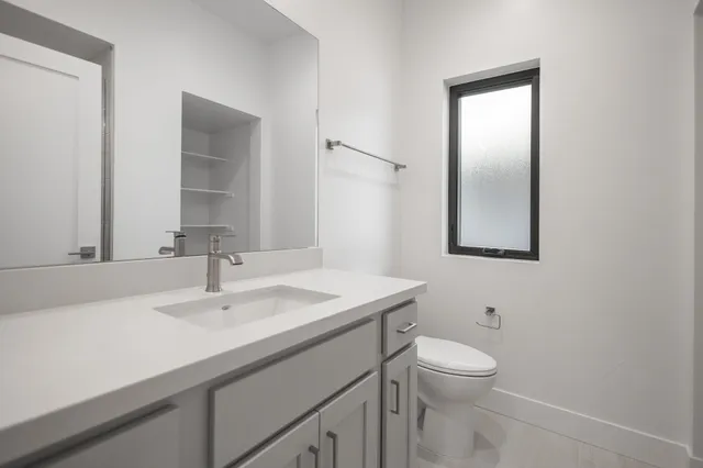 a bathroom with a sink toilet and mirror