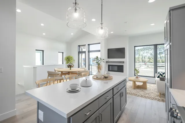 a view of a dining room with furniture a fireplace and wooden floor
