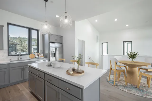 a kitchen with sink stove and white cabinets with wooden floor
