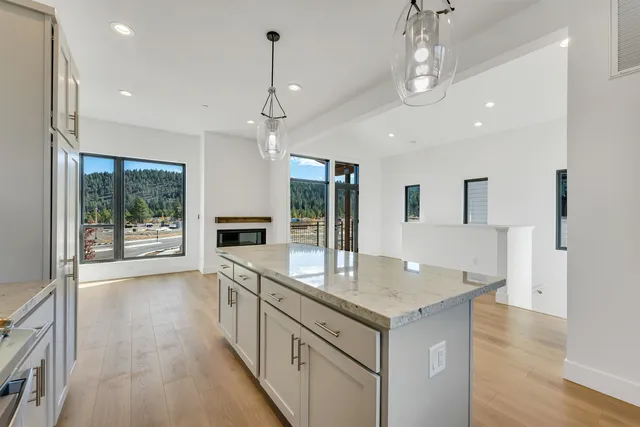 a large kitchen with granite countertop a large island in the center and a wooden floor