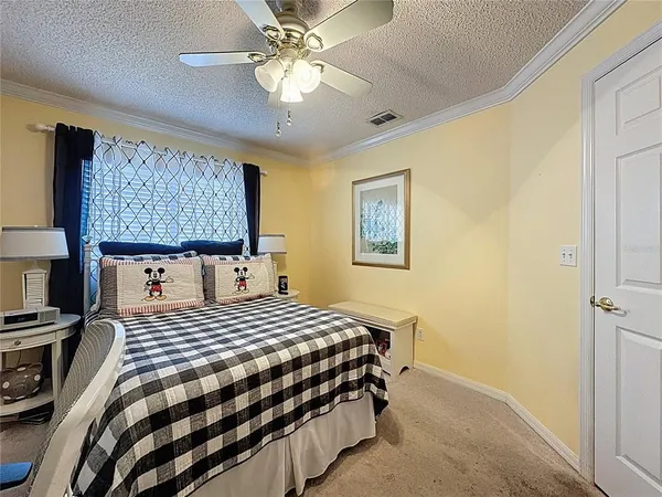 a bedroom with a bed a dresser and a chandelier