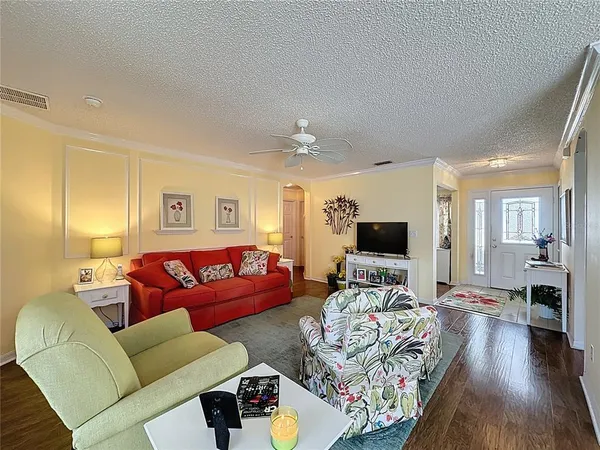 a view of a dining room with furniture a chandelier and wooden floor