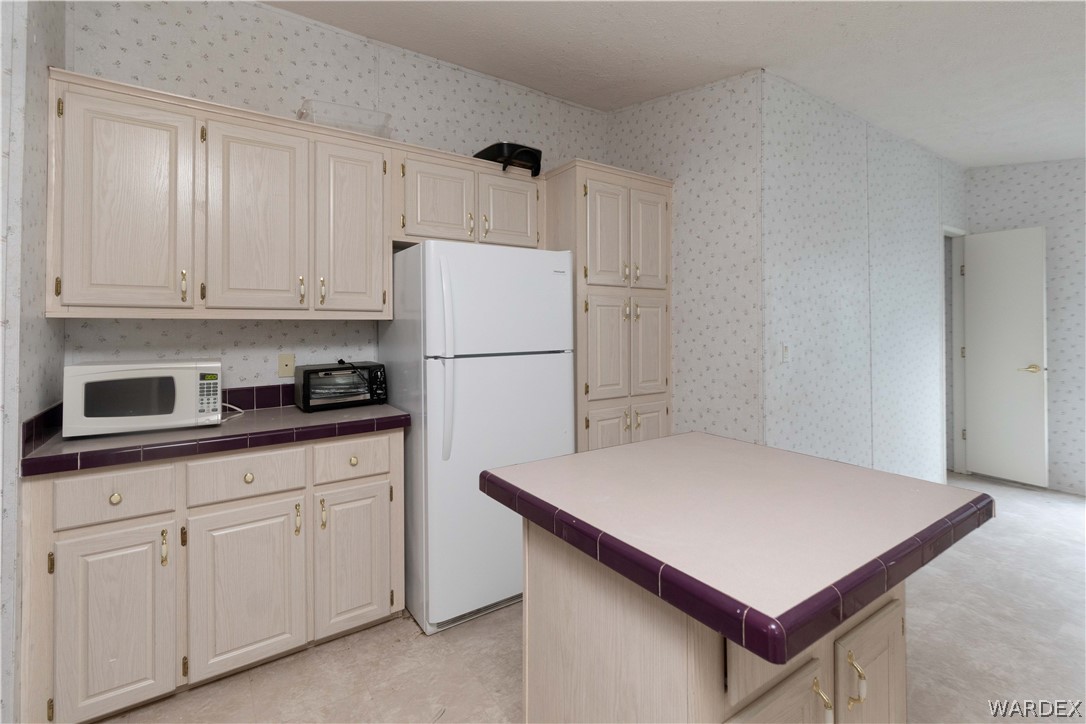7374 Windmill Road Kingman, AZ 86401 - Photo 18 of 49 a kitchen with white cabinets and refrigerator