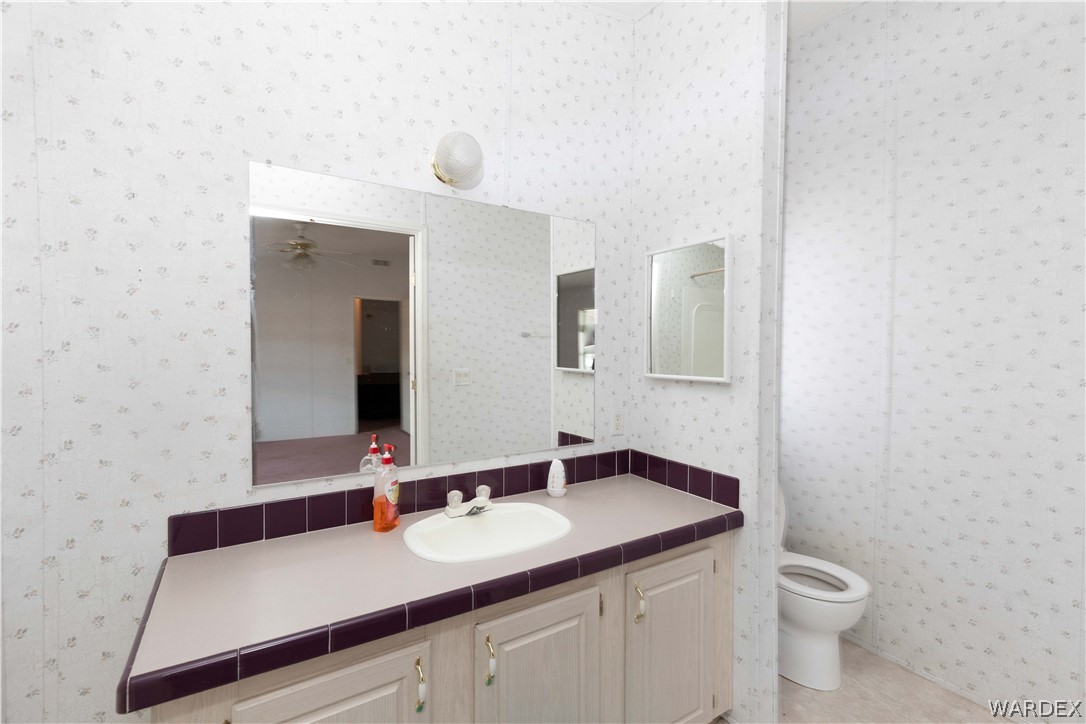7374 Windmill Road Kingman, AZ 86401 - Photo 25 of 49 a bathroom with a toilet sink and mirror