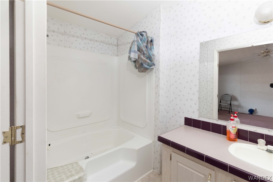 7374 Windmill Road Kingman, AZ 86401 - Photo 26 of 49 a bathroom with a sink vanity granite tub shower and a mirror
