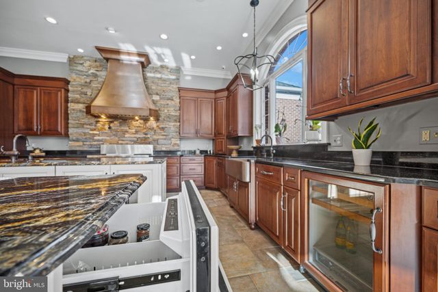 a open kitchen with stainless steel appliances granite countertop a stove and a wooden cabinets