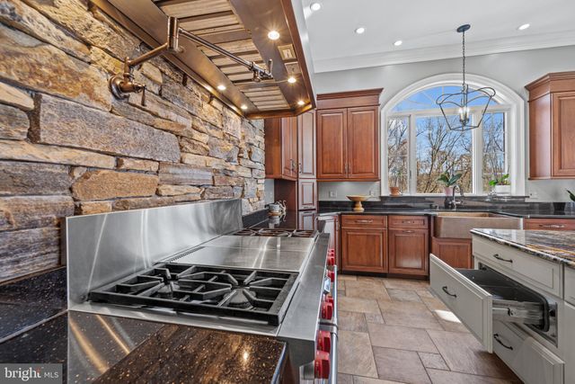 a kitchen with kitchen island a counter top space a sink stainless steel appliances and cabinets