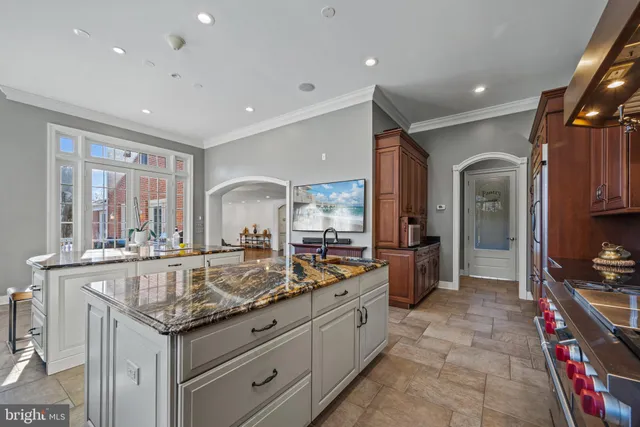 a kitchen with granite countertop a sink a stove a refrigerator and cabinets