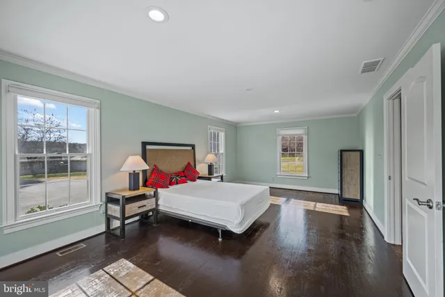 a view of a house next to a big yard with plants and large trees