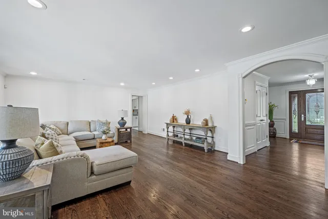 a living room with furniture and hard wood flooring
