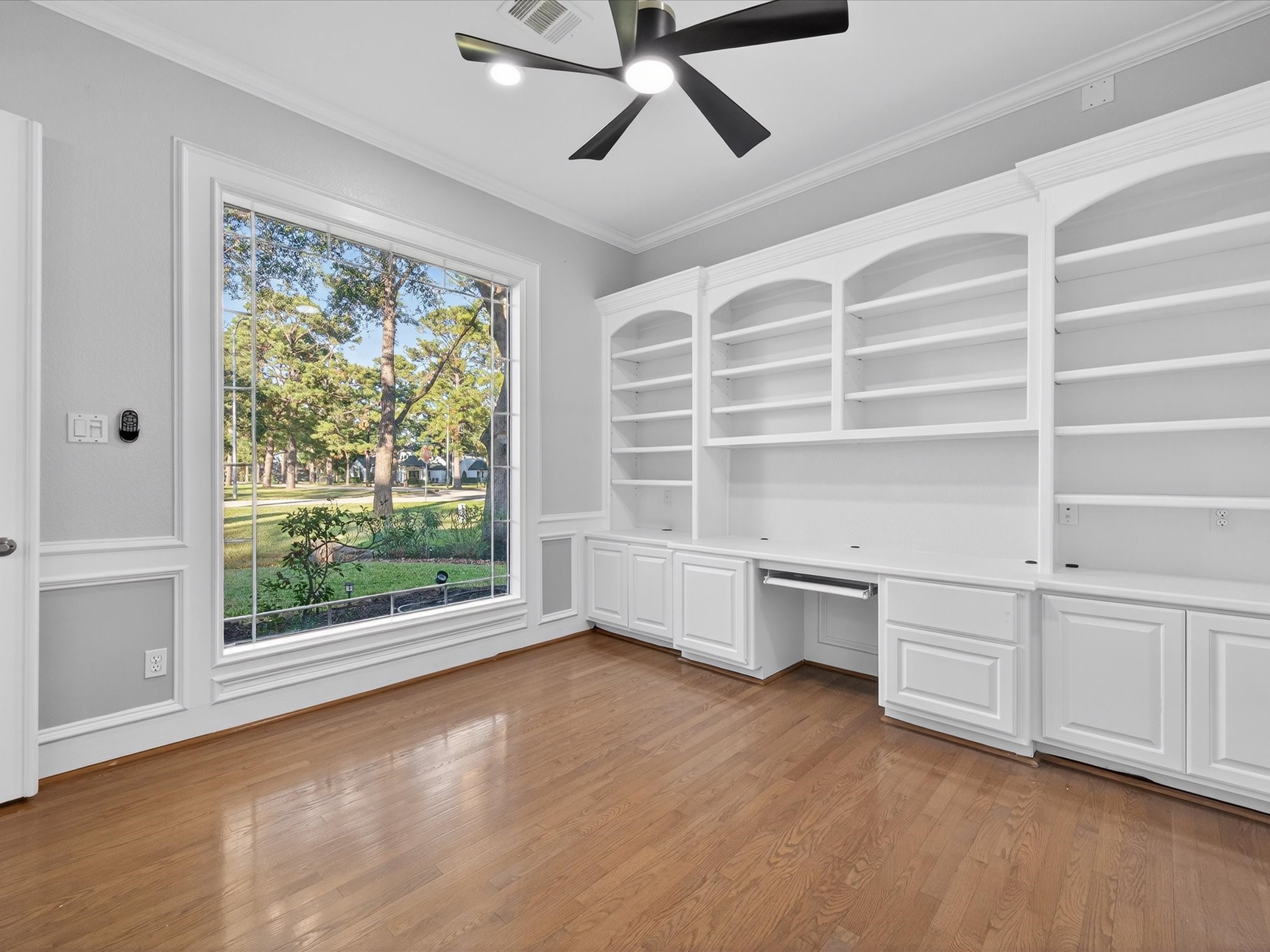 11 Gleannloch Estates Drive Spring, TX 77379 - Photo 12 of 50 The home office features custom built-ins and a large window, with architectural details thoughtfully incorporated throughout for a refined work-from-home experience.