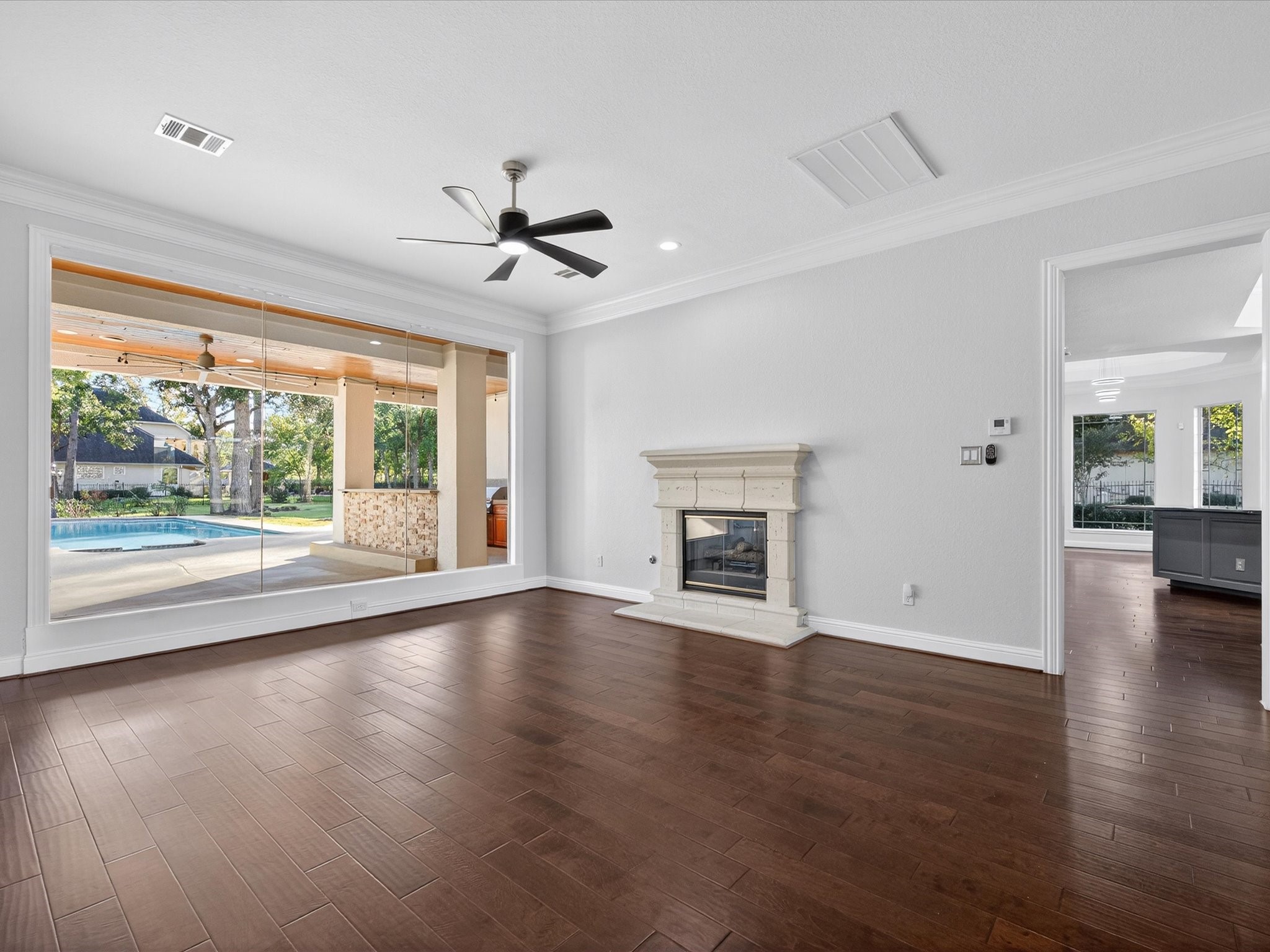 11 Gleannloch Estates Drive Spring, TX 77379 - Photo 13 of 50 The formal living room features a Gaslog fireplace and floor-to-ceiling windows framing views of the backyard oasis, blending warmth and elegance.