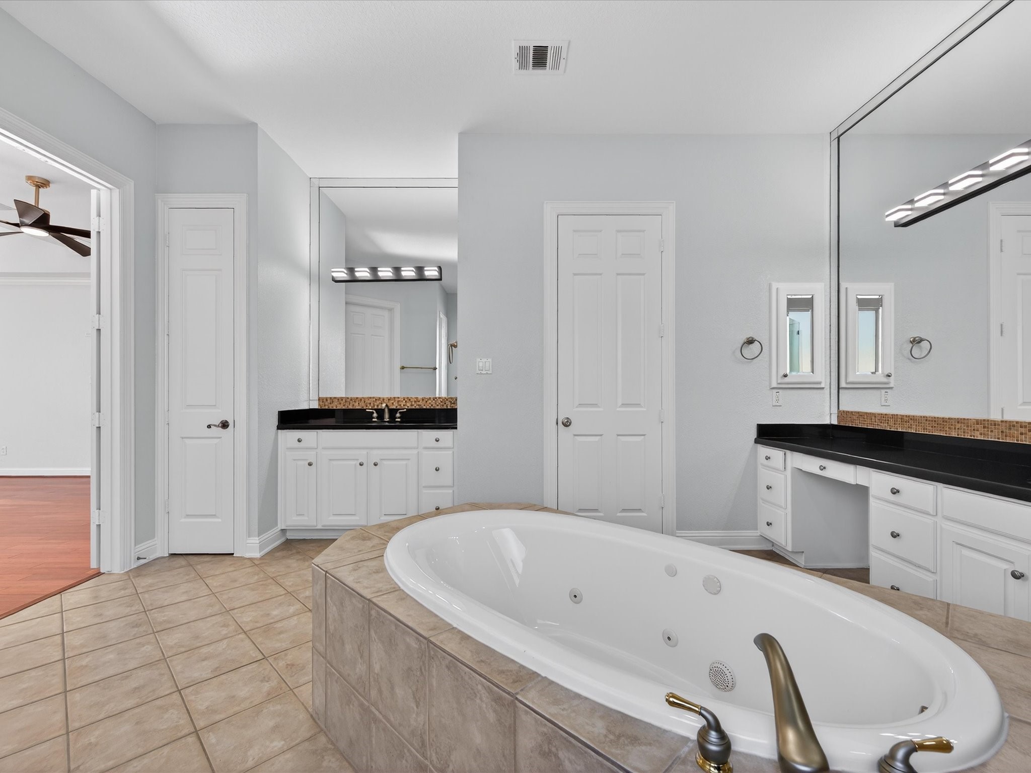 11 Gleannloch Estates Drive Spring, TX 77379 - Photo 23 of 50 The primary en suite boasts dual sinks, vanity space, a jetted tub, separate walk-in shower, and spacious walk-in closets.