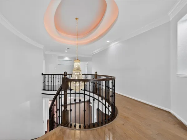 an empty room with wooden floor and a ceiling fan