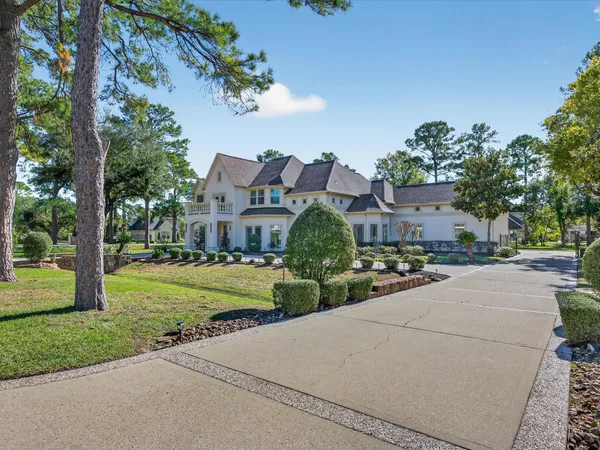 a front view of a house with a garden and trees