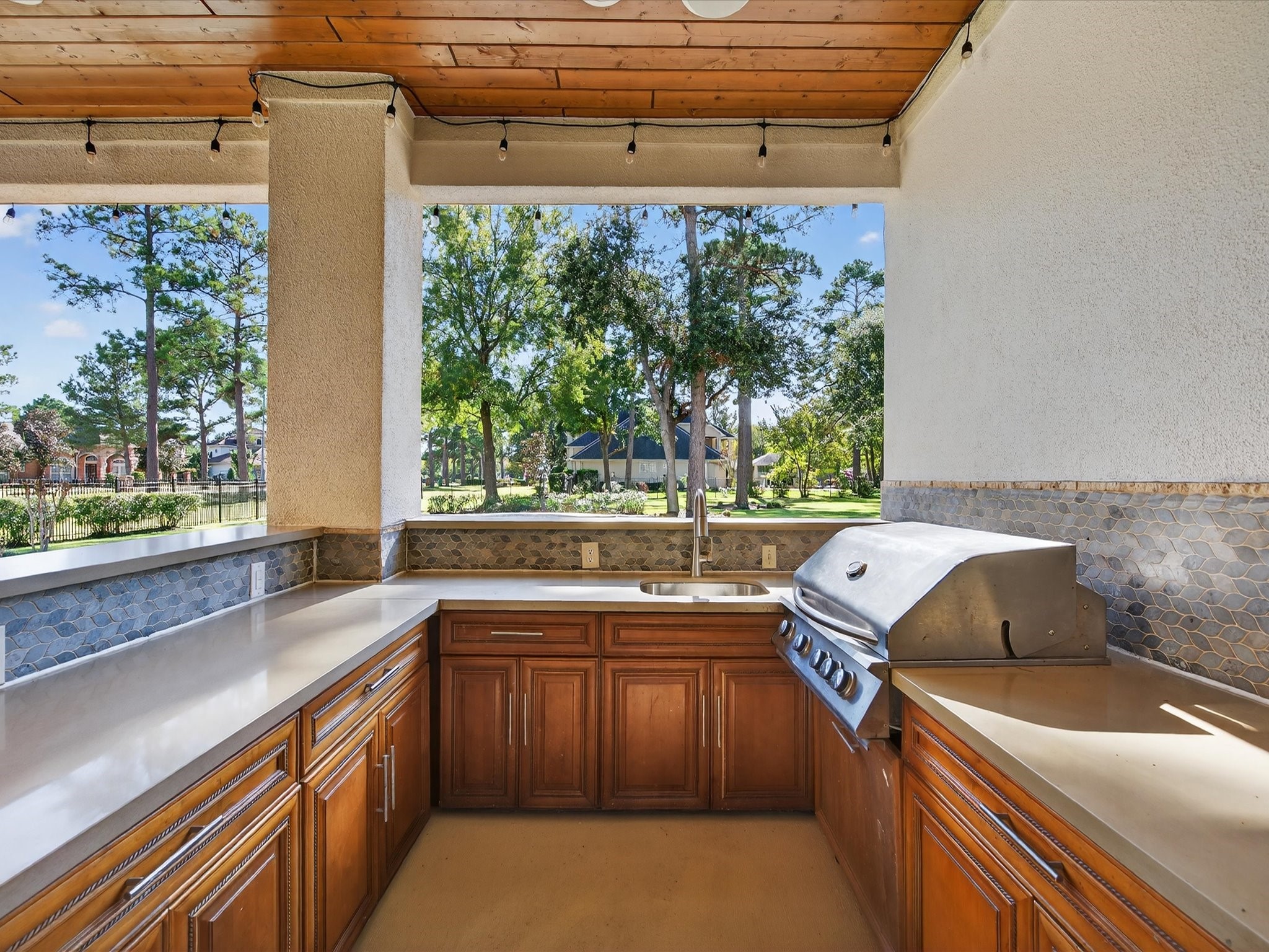 11 Gleannloch Estates Drive Spring, TX 77379 - Photo 36 of 50 The outdoor kitchen includes abundant storage, expansive counters, a sink, 5-burner grill, and gas range oven, ideal for culinary enjoyment outdoors.