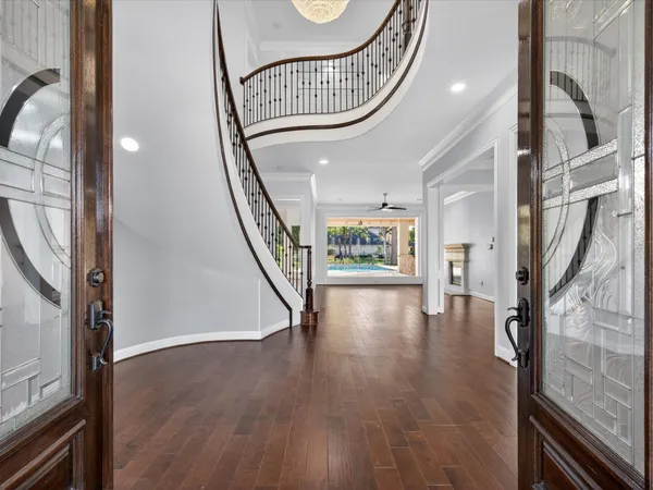 a view of an entryway with wooden floor door and a mirror