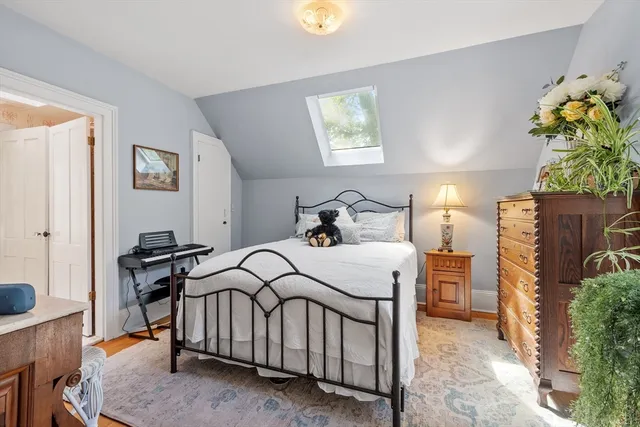 a bedroom with a bed table and a potted plant